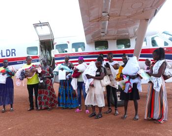 Babies with hydrocephalus and their carers at Tororo Airstrip