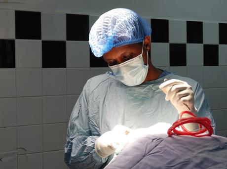 CURE Children's Hospital of Uganda's doctor Caleb removes a shunt from baby Godfrey.